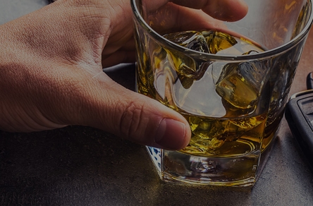 Keys next to an alcoholic drink.