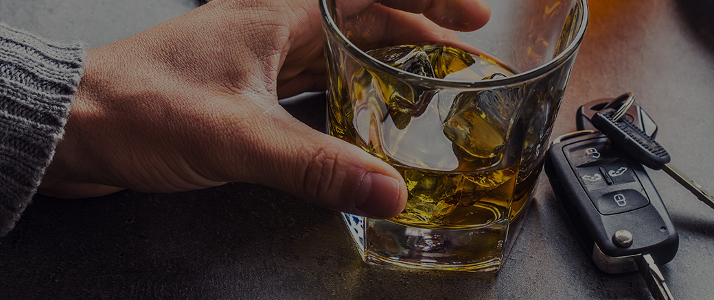 Keys next to an alcoholic drink.